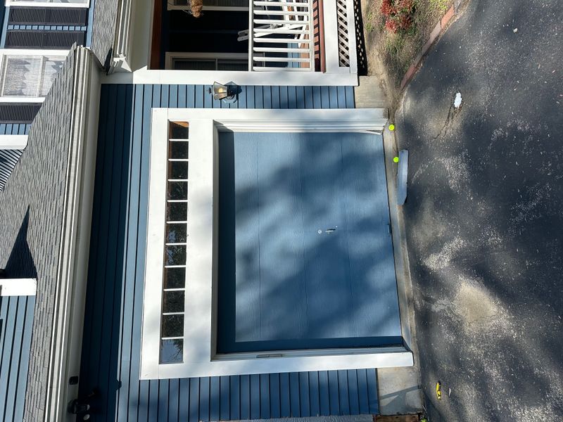 Original blue flush garage door on colonial home before dual door upgrade